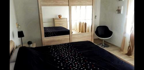 um quarto com uma cama preta e um espelho em chouette appartement 2 chambres em Seraing