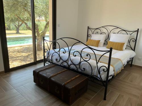 a bedroom with a black bed with a large window at L arbousiere in Sagriès