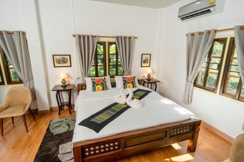 1 dormitorio con 1 cama en una habitación con ventanas en Baan innto resort en Fang