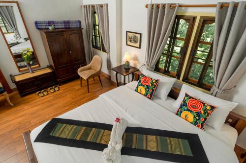 a bedroom with a large white bed with pillows at Baan innto resort in Fang