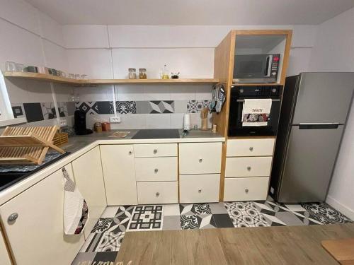 a kitchen with a black and white tile floor at La Maison de Paofai in Papeete
