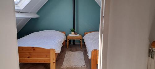 two twin beds in a room with a window at Polderrust in De Haan