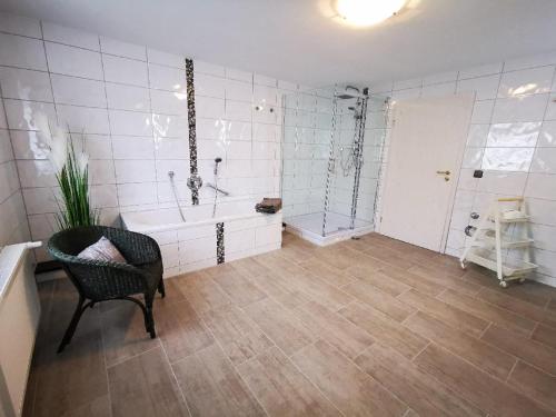 uma casa de banho com uma banheira, um WC e uma cadeira em Ferienwohnung Neuerer em Riedlhütte