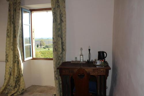 Habitación con mesa de madera y ventana. en Le Clos Saint Georges, en Donnazac