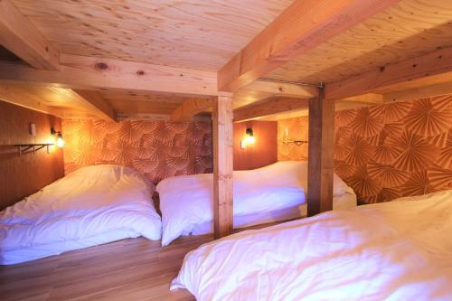 2 Betten in einem Zimmer mit Holzwänden in der Unterkunft Sumida-ku - House / Vacation STAY 80877 in Tokio