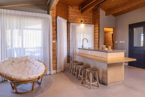 a kitchen with a counter and a sink and stools at Kibbutz Ortal Tourism in Ortal