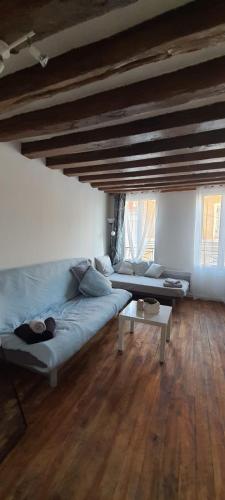 a living room with a blue couch and a table at Attrayant studio tout équipé en Bord de Marne - Proche Disney in La Ferté-sous-Jouarre
