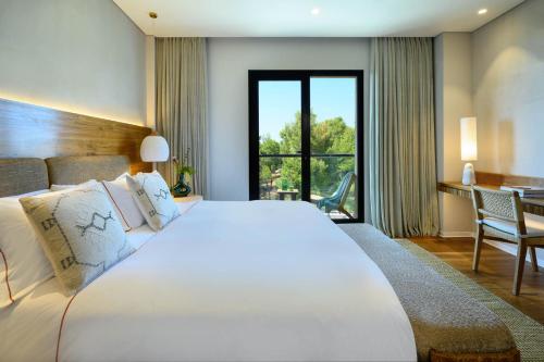 a bedroom with a large white bed and a desk at Cnaan Hotel- Limited Edition By Fattal in Safed