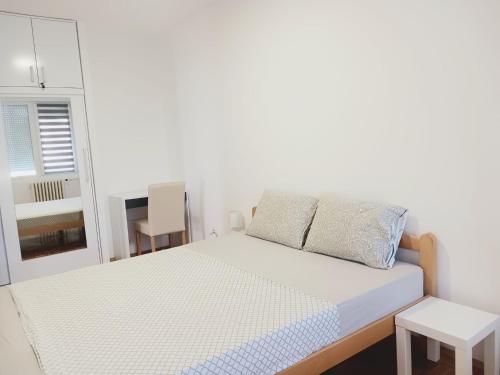 1 dormitorio blanco con 1 cama y 1 silla en Comfort Apartment en Novi Beograd