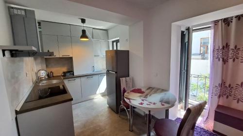 una cocina con una mesa pequeña y una mesa pequeña y una mesa en Ris studio dublu universitate, centrul vechi, en Bucarest