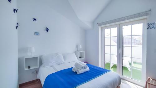 a bedroom with a bed with a towel on it at Ó da Casa in Peniche