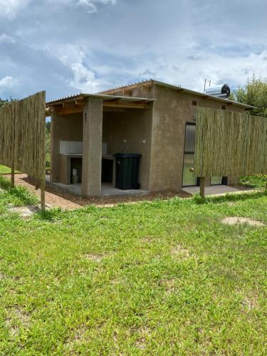 a house with a fence in front of it at Mababe River Campsite in Mababe