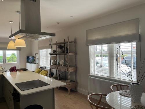 a kitchen with a counter and a table and some windows at Stunning Beachfront Apartment in Cleethorpes