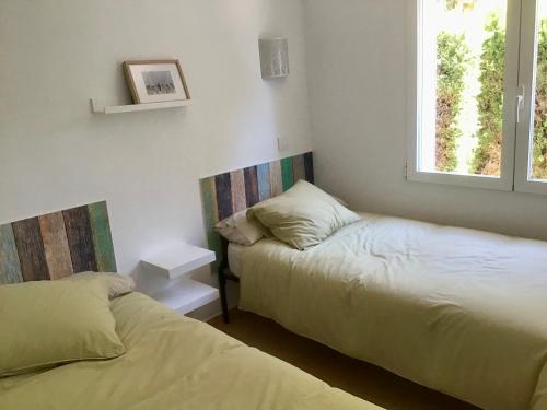 1 Schlafzimmer mit 2 Betten und einem Fenster in der Unterkunft Casa de 2 dormitorios con piscina, 2 terrazas privadas, WIFI, BBQ in Denia