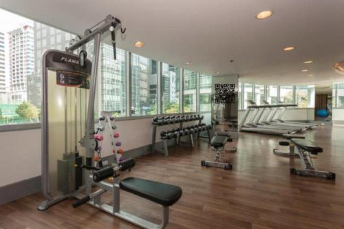 a gym with treadmills and machines in a building at Avant Apartments at The Fort in Manila