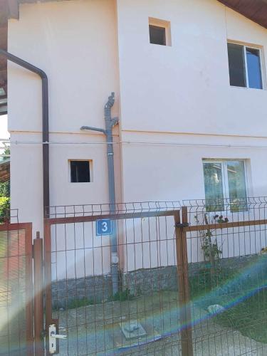 a fence in front of a white building at Casa Marieta in Breaza de Sus