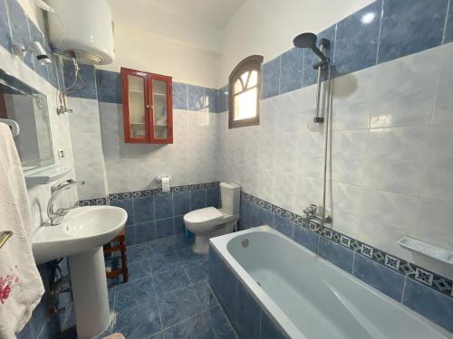 La salle de bains est pourvue d'une baignoire, de toilettes et d'un lavabo. dans l'établissement Gîte Hôtel Gezira Louxor, à Louxor