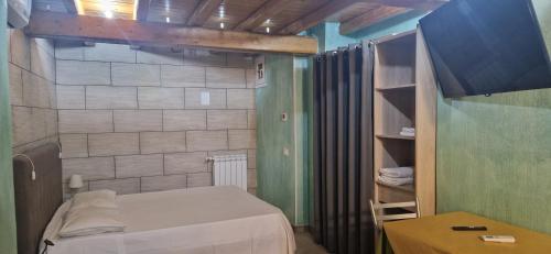 ein kleines Zimmer mit einem Bett und einem Regal in der Unterkunft B&B Mongibello in Viagrande