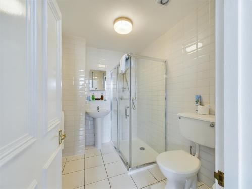 uma casa de banho com um chuveiro, um WC e um lavatório. em Beech House Hotel em Reading