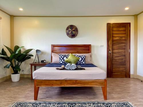 a bedroom with a bed with a wooden head board at Beautiful 2BD Farmhouse for 4-10 pax in Ormoc