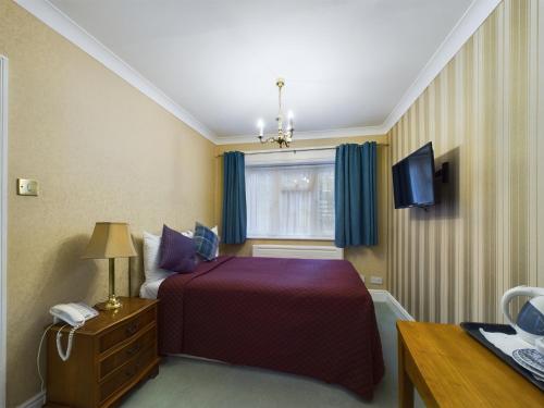 a hotel room with a bed and a window at Beech House Hotel in Reading