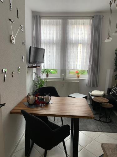 a living room with a wooden table with chairs and a window at Fewo-Liza in Wernigerode