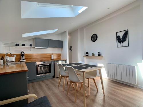 cocina con mesa y sillas en una habitación en Appartement cosy avec parking, en Dinsheim