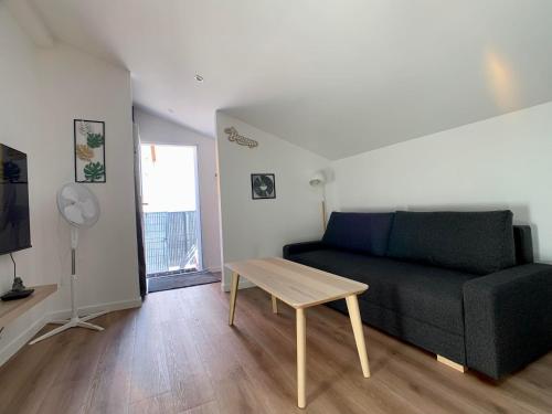 sala de estar con sofá y mesa en Appartement cosy avec parking, en Dinsheim