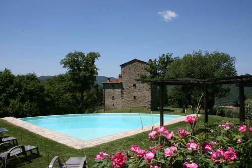 una piscina di fronte a un edificio fiorito di Torre Di Vignale a Palazzo del Pero