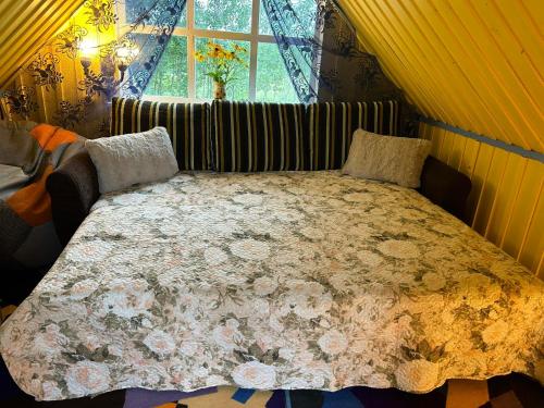 Un dormitorio con una cama grande con una manta de flores en Valgemaja Majutus, 