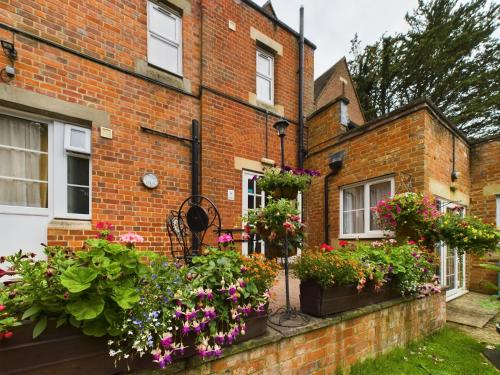 a brick house with lots of flowers in front of it at Beech House Hotel in Reading