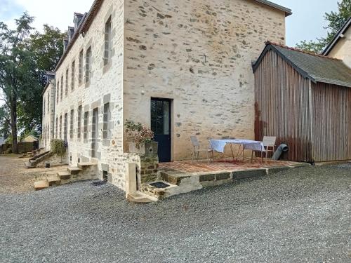 un edificio con una mesa fuera de él en Appartement au manoir de la grande vigne Mayenne, en Mayenne