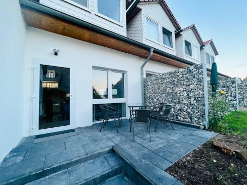 a patio with chairs and a table in front of a house at App 8u Heimatliebe in Dranske