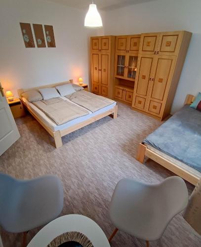 a bedroom with a bed and two chairs in it at Park Nyaralóház in Badacsonytomaj