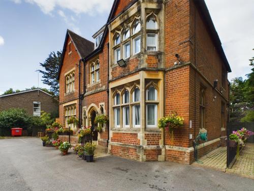 an old brick building with potted plants on it at Beech House Hotel in Reading