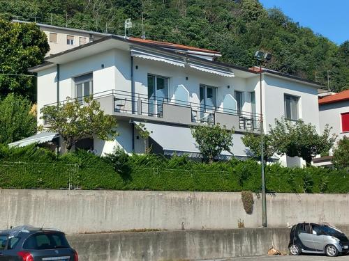 a white house with cars parked in front of it at IL MELOGRANO HOLIDAY COMO in Como