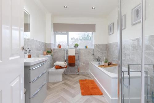 a white bathroom with two sinks and a shower at Enchanting Haven in Todmorden