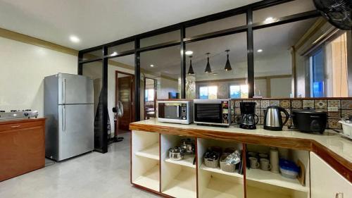 a kitchen with a counter with microwaves and a refrigerator at Beautiful 2BD Farmhouse for 6pax in Ormoc