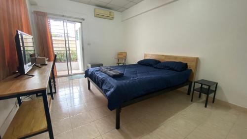 Schlafzimmer mit einem Bett, einem Schreibtisch und einem Fenster in der Unterkunft ธนทรัพย์อพาร์ทเม้นท์ Room02 in Pathum Thani