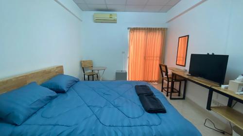 a bedroom with a large blue bed and a television at ธนทรัพย์อพาร์ทเม้นท์ Room02 in Pathum Thani