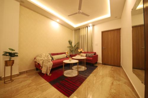 a living room with a red couch and a table at Perfectstayz Value Homes Mussoorie 120 meters uphill in Mussoorie