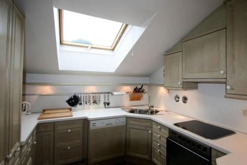 a kitchen with wooden cabinets and a skylight at Ferienwohnung Erika in Oberstdorf