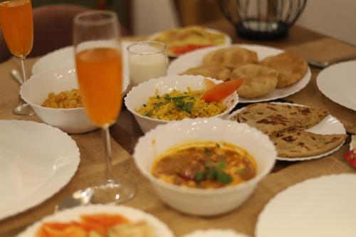a table with plates of food and glasses of drinks at Perfectstayz Value Homes Mussoorie 120 meters uphill in Mussoorie