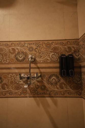a bathroom wall with a faucet on a wall at Perfectstayz Value Homes Mussoorie 120 meters uphill in Mussoorie