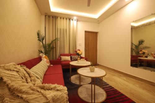 a living room with a red couch and two tables at Perfectstayz Value Homes Mussoorie 120 meters uphill in Mussoorie