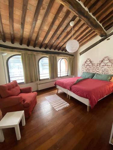 a bedroom with a bed and a couch and a chair at Alle Casine in Lucca