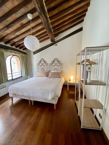 a bedroom with a white bed and a wooden floor at Alle Casine in Lucca