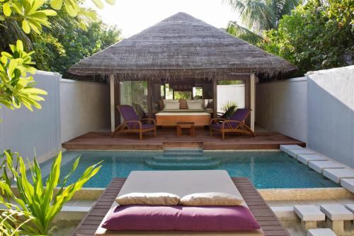 een resort met een bed en een zwembad bij Coco Bodu Hithi in North Male Atoll