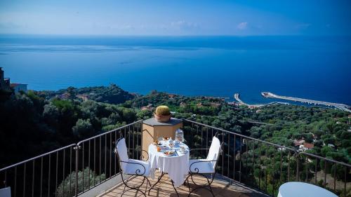 uma mesa e cadeiras numa varanda com vista para o oceano em Marulivo Hotel em Pisciotta