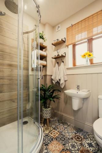 a bathroom with a shower and a toilet and a sink at The Former New Inn, air conditioning in Ashby de la Zouch